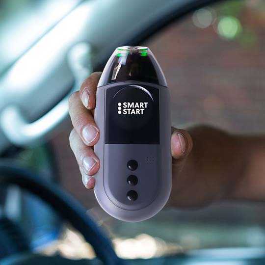 Close-up of a person holding a Smart Start 3030 ignition interlock device